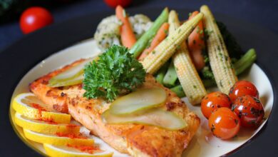 A beautifully plated salmon dish with fresh vegetables and lemon slices, perfect for a gourmet meal.